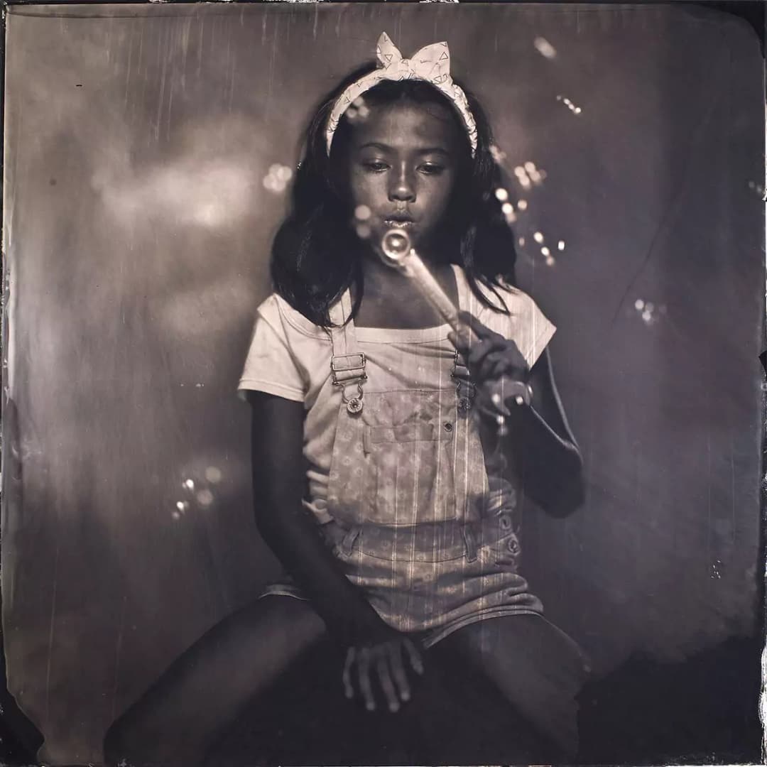 Collodion picture of a young girl playing with bubbles.