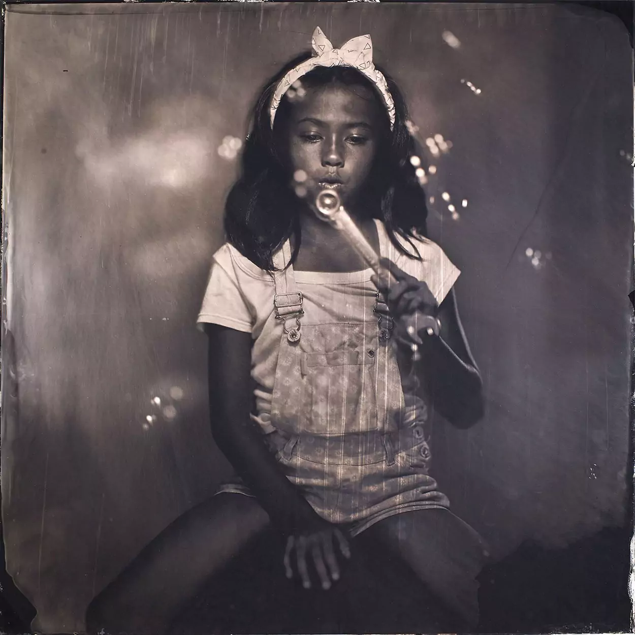 Collodion pitcure of a young girl playing with bubble.