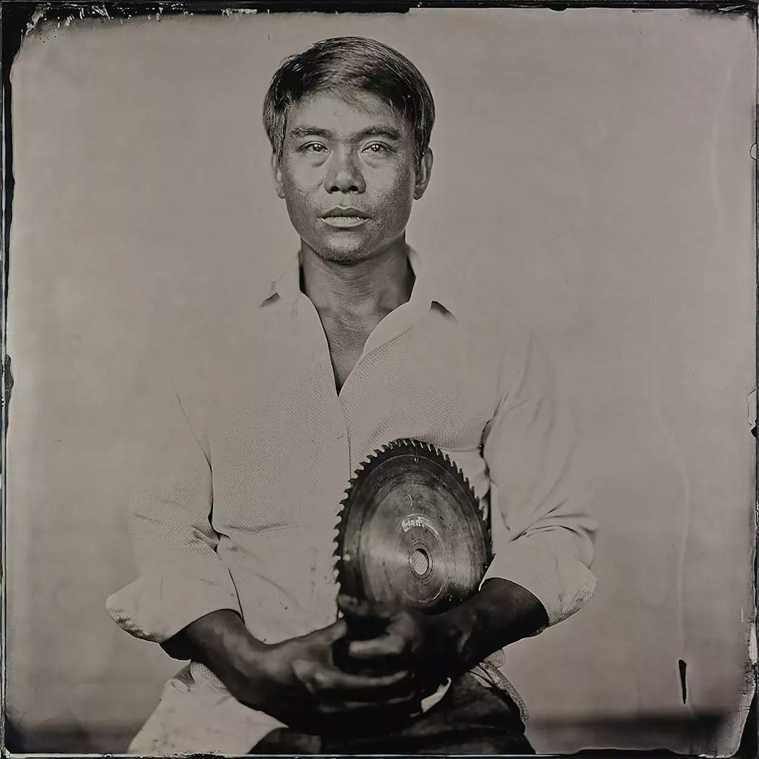Collodion picture of a Vietnamese man holding a circular saw.